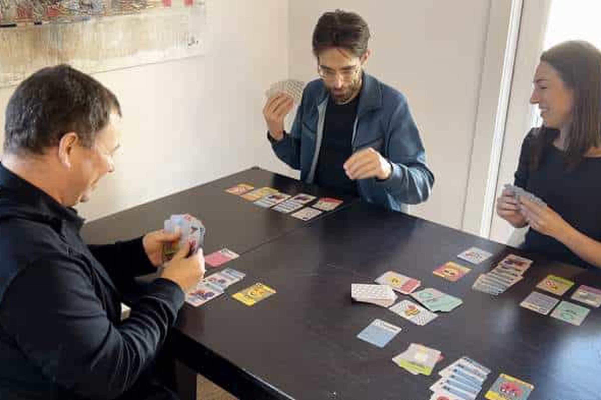 A group of people playing a card game, One Billion Users.