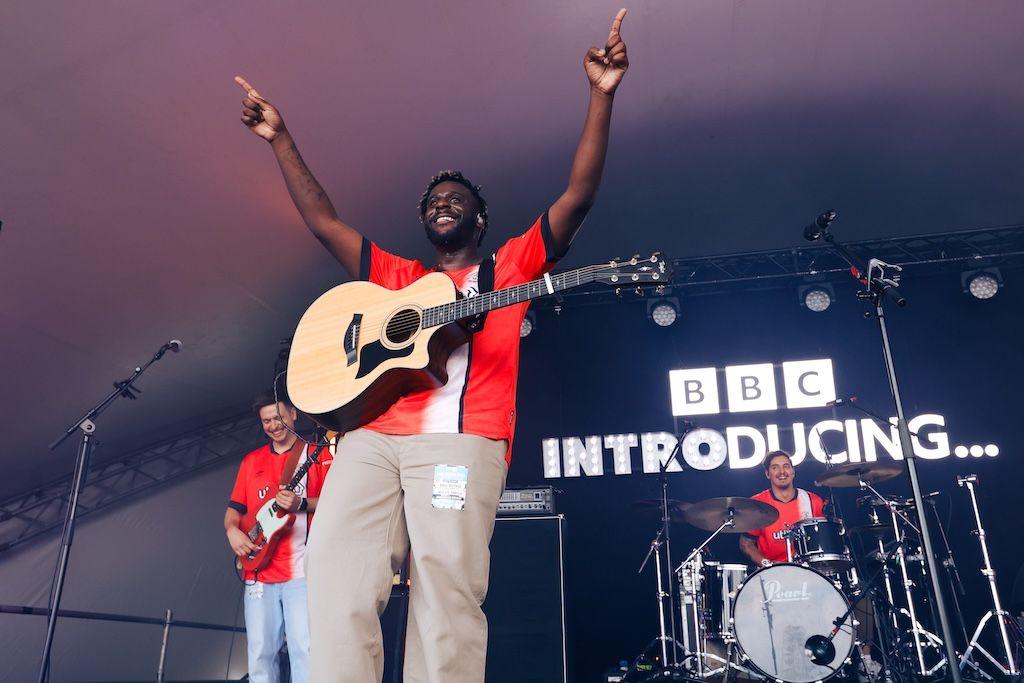 Myles Smith holds his arms above his head and conducts the audience as he performs at Radio 1's Big Weekend in Luton, May 2024