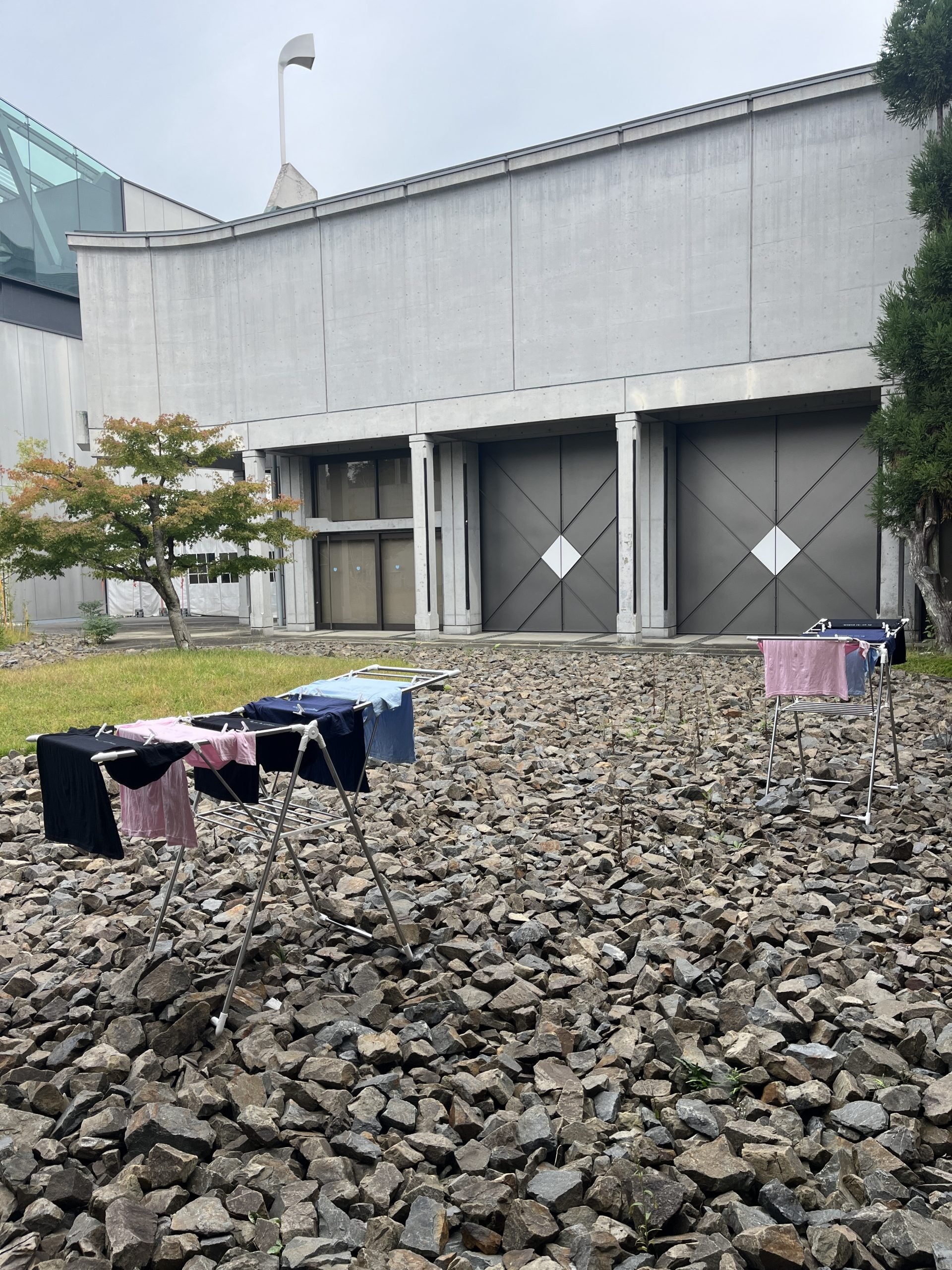 In a stone garden, clothes dry on a clothes dryer.