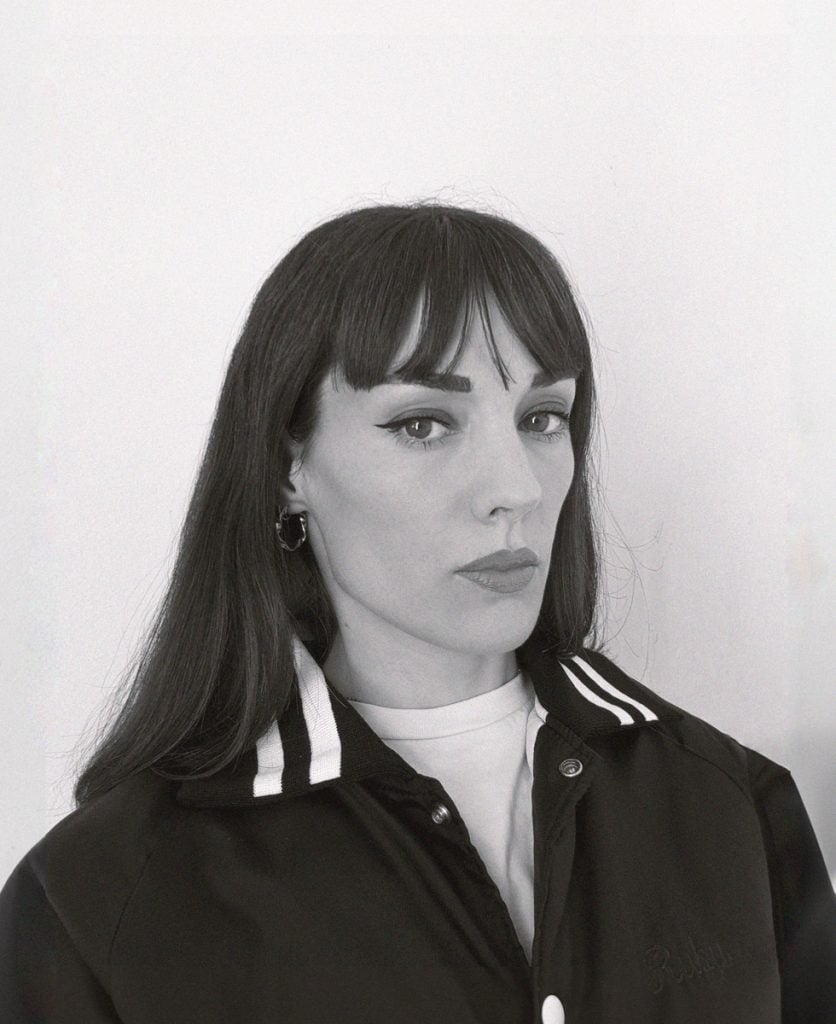 ablakc and white portrait of an artist in a baseball jhackwet and long hair with bangs 