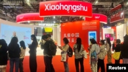 FILE - Visitors line up near the booth for Xiaohongshu app at the China International Import Expo in Shanghai, China, Nov. 6, 2024.