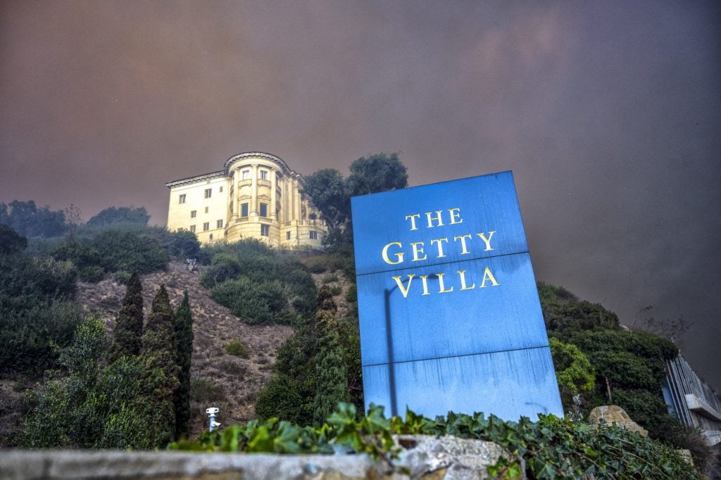 photo of the getty villa in LA with a smoke-darkened sky behind it