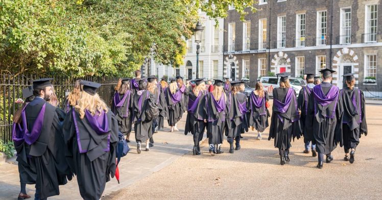 Graduate students walking out of the ceremony in London.