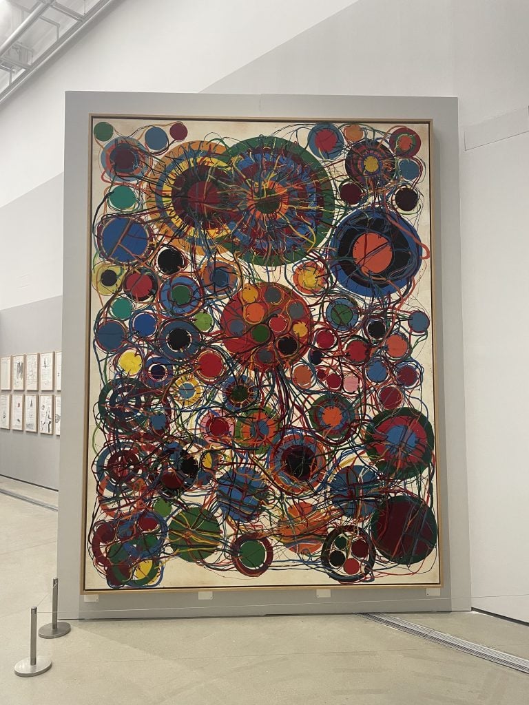 A large painting showing many colourful circles on a white canvas