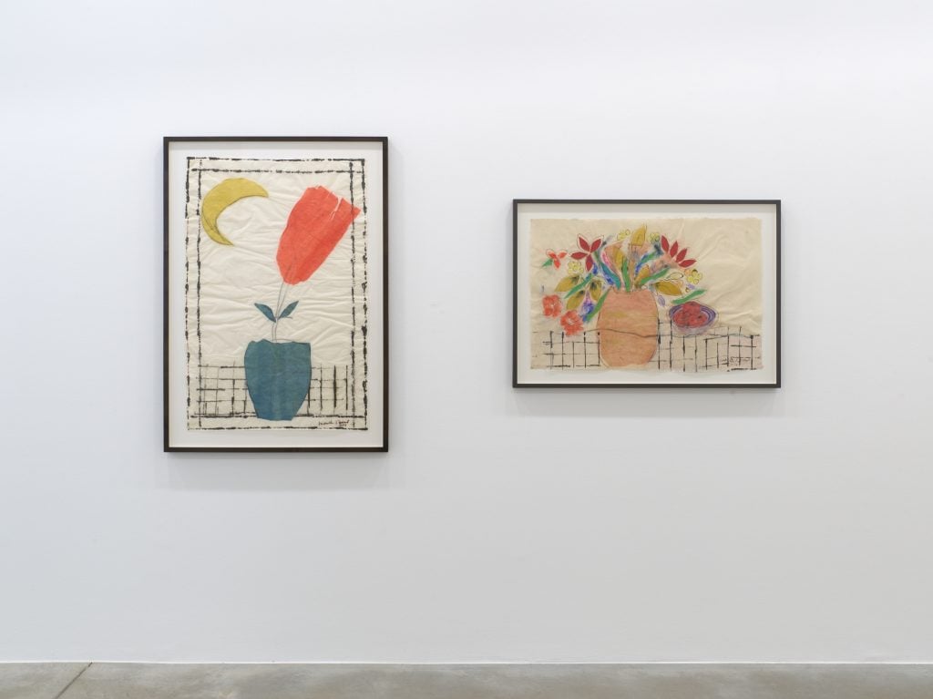 two artworks of vases with colorful flowers hanging on a white wall