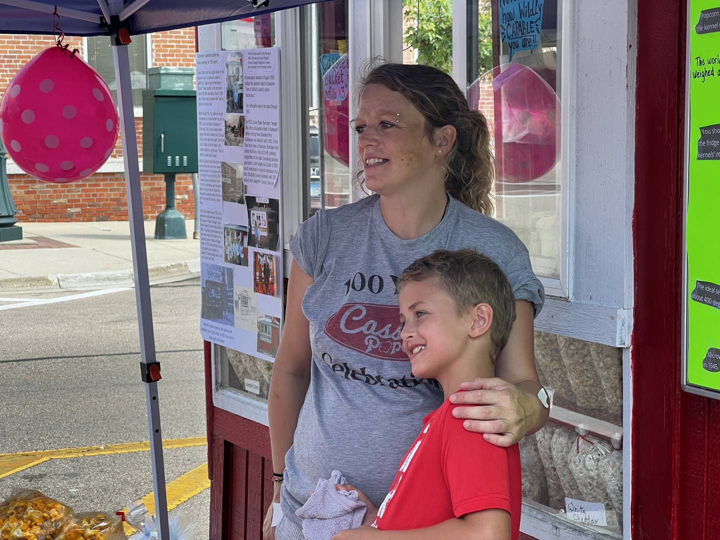 Leah Oltman and her son, Cayson Oltman stand together before Cassie's popcorn stand opens for its centennial celebration on July 25, 2024 in downtown Sycamore.