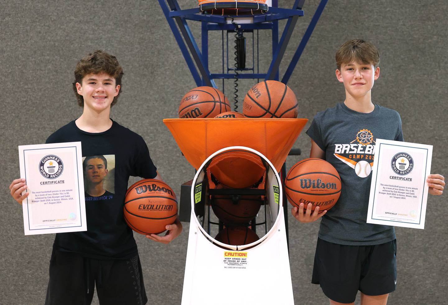 Cole Krueger, (left) 15, and his brother Caleb, 13, show off their Guinness World Record certificates Wednesday, Aug. 28, 2024, at their house in Genoa. The two hold the record for the most basketball passes in a minute for a pair under 16 and they are planning to attempt breaking the world record for the most three pointers in a minute by a duo.