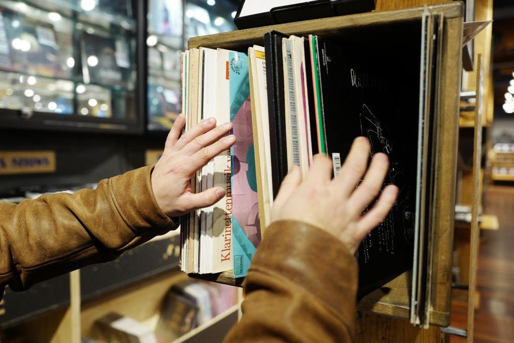 Hands sift through vinyl records.