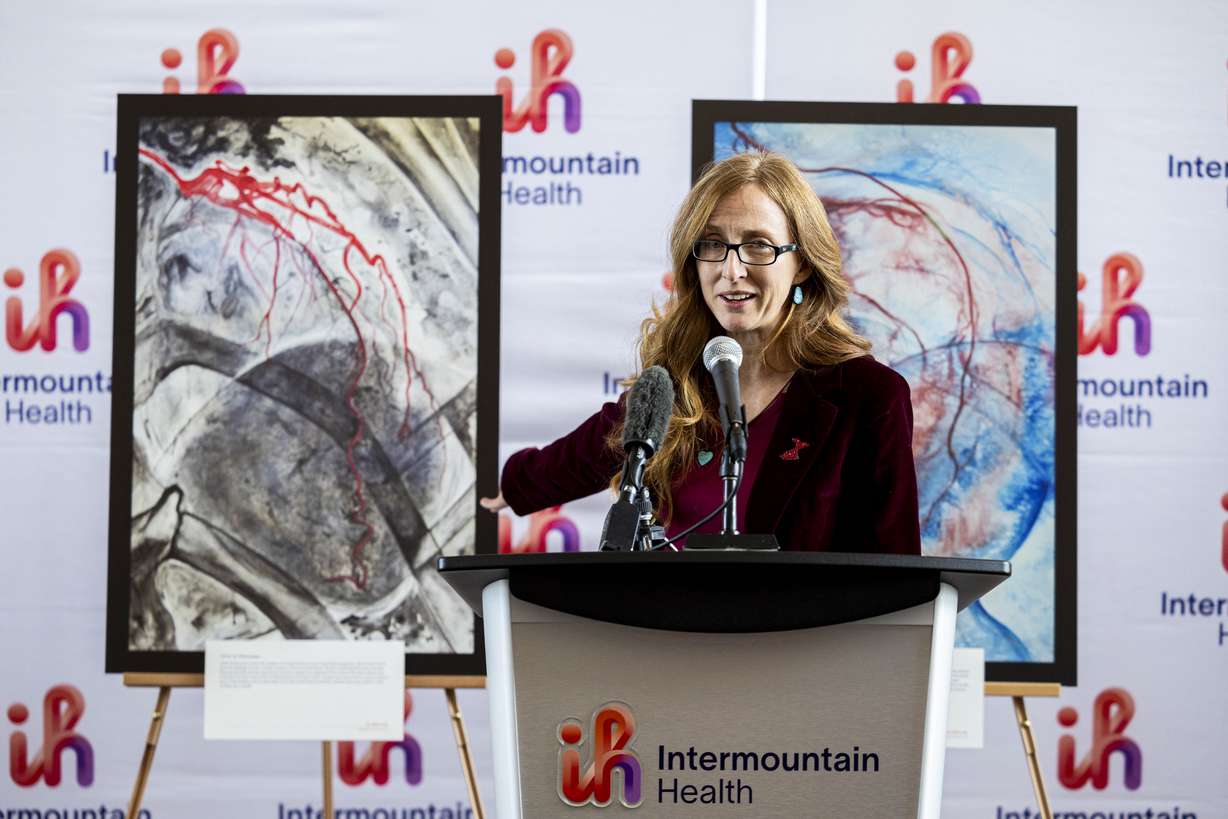 Kimberleigh Collins-Peynaud, an artist and heart attack survivor, gestures to one of her pieces of art as she speaks during a press conference concerning heart disease in women held at the Intermountain Medical Center in Murray on Thursday.