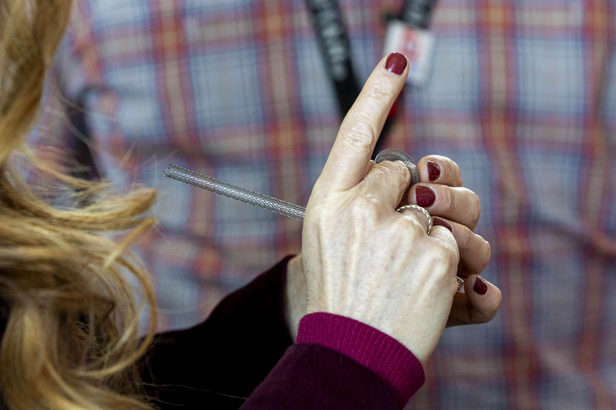 Kimberleigh Collins-Peynaud, an artist and heart attack survivor, checks out stents for different parts of the body after a press conference concerning heart disease in women held at the Intermountain Medical Center in Murray on Thursday.