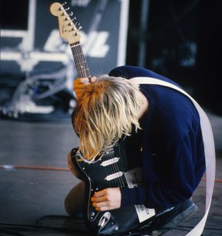 Kurt Cobain leans over his guitar onstage at the Pukkelpop Festival in Hasselt, Belgium on August 25, 1991