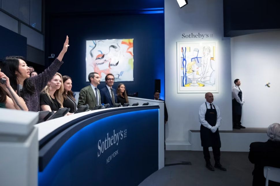 Image of auction specilalists on teh phone bidding at Sotheby's