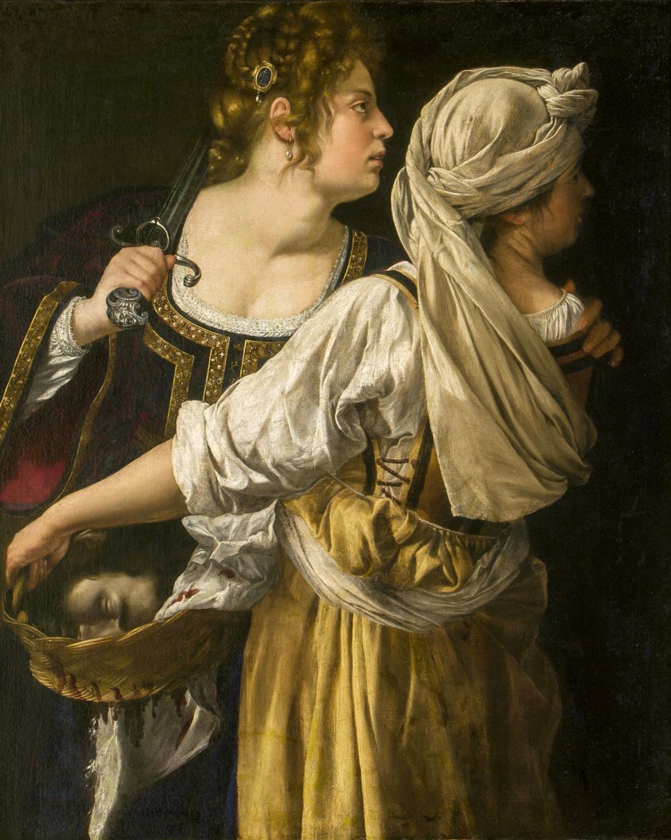 Two women in historical dress walk side-by-side, one carrying a sword and the other holding a basket containing a man's severed head.