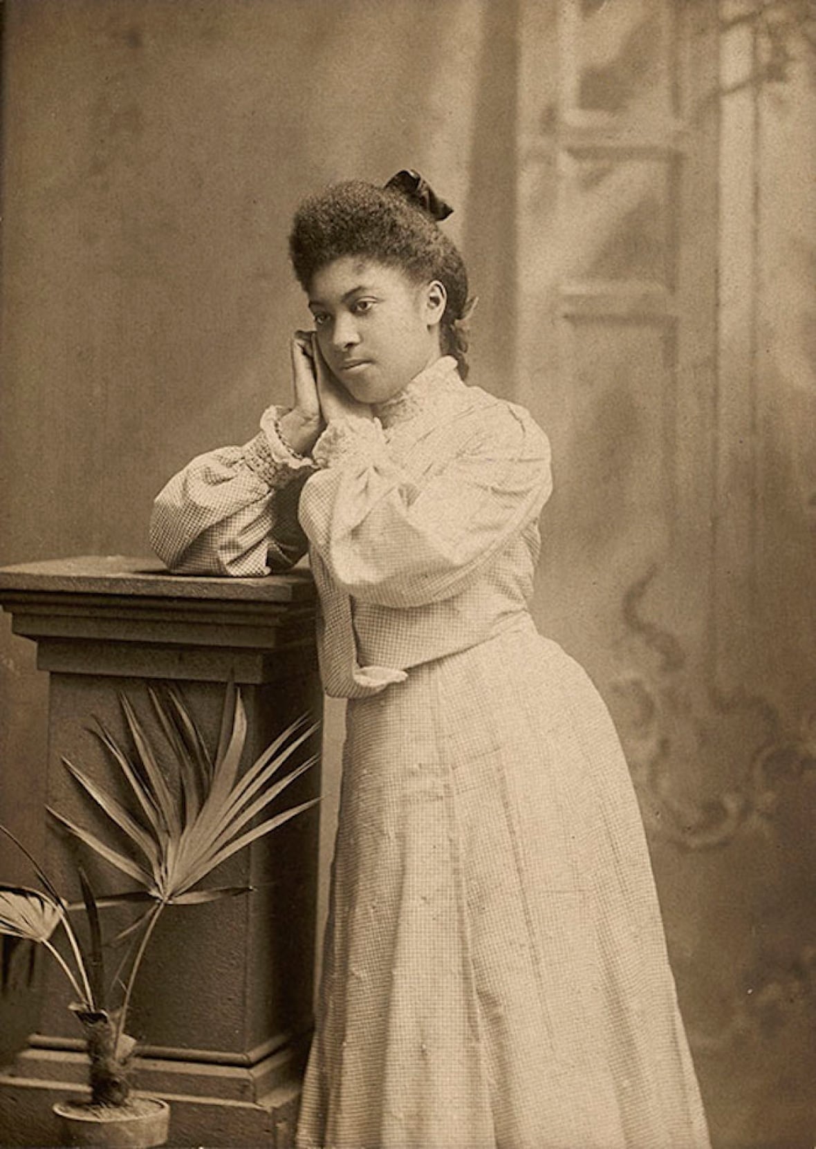 Black and white photo of a teenage girl in Victorian formal clothes