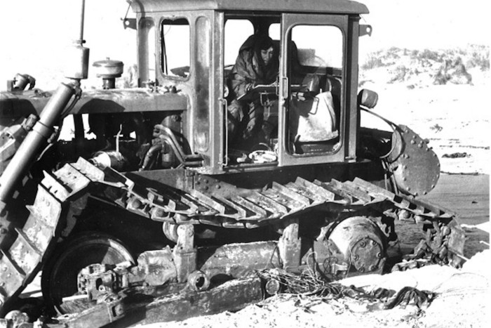 A black and white photo of a woman in a tractor 