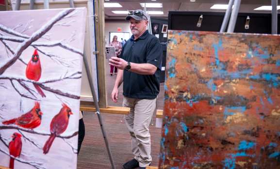 More than 100 artists, their guests and Med Center employees attended the kickoff reception of the 33rd Annual Med Center Health’s Women in the Arts Exhibit Thursday, March 13, 2025 at the The Medical Center-WKU Health Sciences Complex. Winners were announced and awards were handed out during the event. The art exhibit is scheduled for Friday, March 14 and Saturday, March 15 at The Medical Center-WKU Health Sciences Complex. According to Med Center Health, the event provides female artists with an opportunity to showcase their work. The exhibit is open to any female artist over 18 years old residing in Kentucky. Artists may enter their artwork in the following categories: painting, sculpture, ceramics, works on paper, fiber works and photography. Awards include Special Purchase, Cash Merit, Honorable Mention, and ArtWorks Award. The exhibition committee and a juror will select the 2025 Special Purchase Award piece which will be purchased by and displayed at The Medical Center. (Daily News photo by Joe Imel)