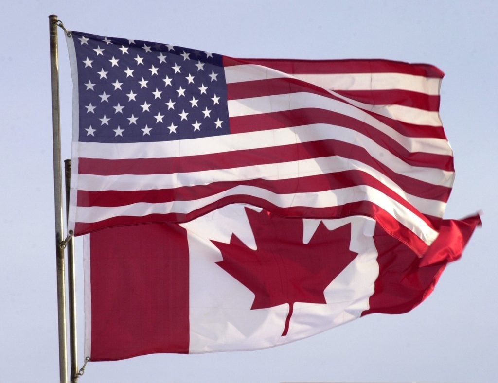 The Canadian and American flags fly side-by-side outside