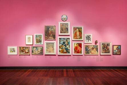 Paintings on a pink wall in a gallery