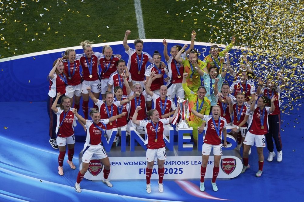 Arsenal's Kim Little, centre, holds the trophy as she celebrates with her teammates after winning the women's Champions League final soccer match between Arsenal and FC Barcelona at the Jose Alvalade Stadium in Lisbon, Saturday, May 24, 2025. (AP Photo/Ana Brigida)