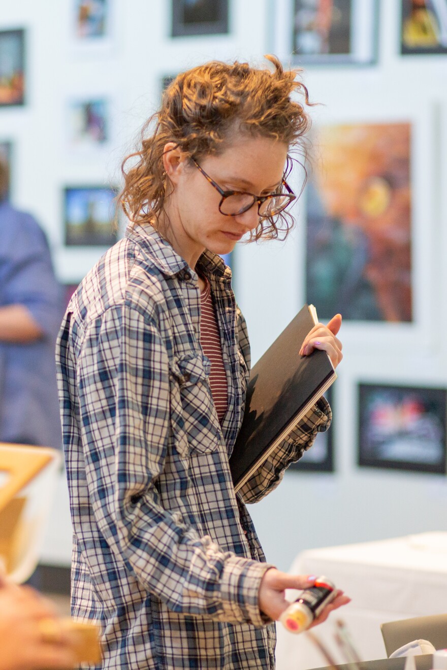 Abby Ausherman, a WSU master's printmaking student and local art teacher, picks up art supplies at a Wichita Women Artists meeting on March 20. Alongside regular critique and updates, WWA hosted an in-group sale of its art supplies.