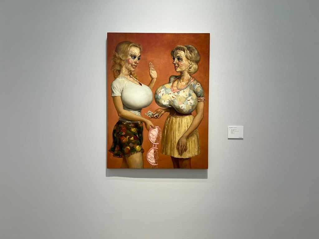 A satirical painting of two heavily stylized women with exaggerated features, smiling and interacting against a warm, reddish background, one handing a pink bra to the other.