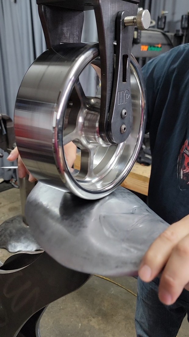 On an English wheel machine he fabricated, Steve Nielsen shapes...
