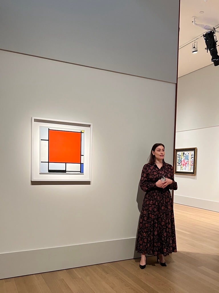 Art expert standing beside Piet Mondrian’s 1922 painting Composition with Large Red Plane, Bluish Gray, Yellow, Black and Blue at Christie’s New York before the auction sale in 2025.