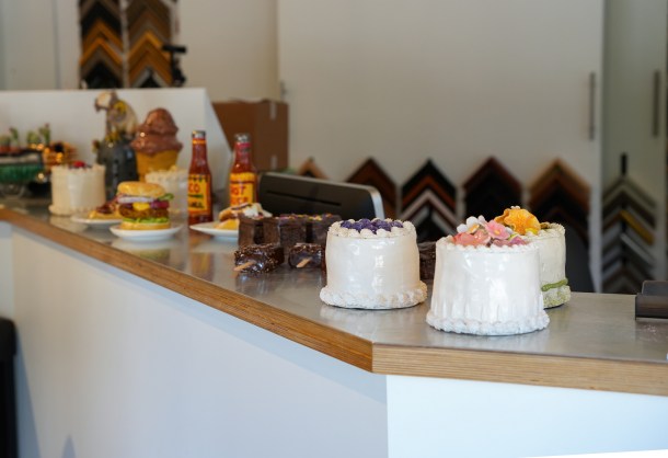 Jeff Nebeker’s popular ceramic cakes and other sculptures welcome visitors to Elliot Fouts Gallery. Nebeker’s art has had viral success through social media marketing.  (Photo by Marie-Elena Schembri)