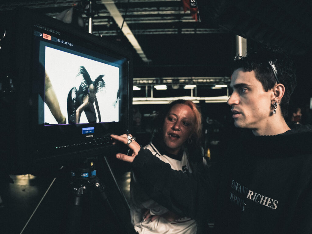 Choreographer and producer reviewing the music video on screen.