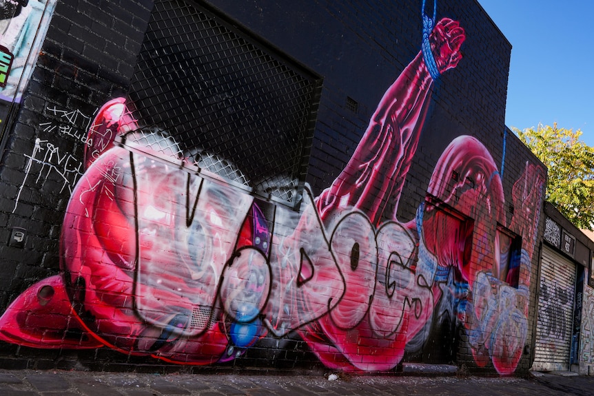 A person sitting in front of a mural