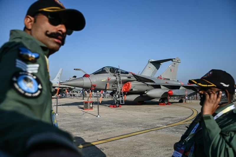 Indian Air Force personnel stand in front of a Rafale fighter jet during a military aviation exhibition at the Yelahanka Air Force Station in Bengaluru.
