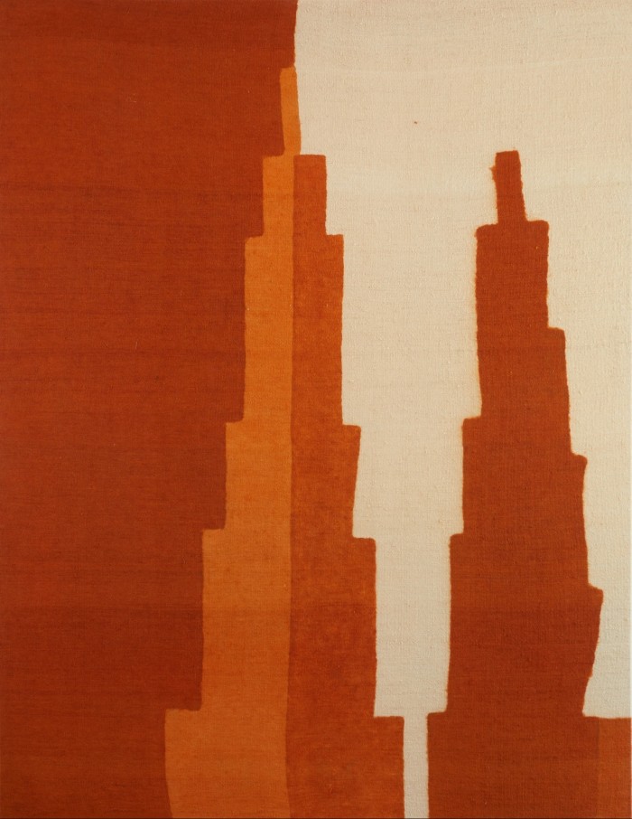 Woven fabric piece of art, in a portrait format, where two pointy triangles are set against a darker red and white background